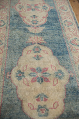 Distressed aqua teal field with ivory scalloped medallion and pink floral motifs on Oushak rug.