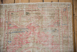 Worn pile on a distressed Turkish Oushak showing the knot heads in beige, pink, and blue.