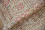 Evenly worn texture of a distressed Oushak rug, showing the knot heads in soft pink and sand.