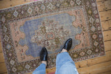 Overhead lifestyle view of a distressed Oushak rug showing its scale and worn texture.