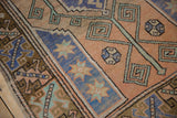 Faded blue starburst floral motifs and terracotta geometric patterns on Melas rug.