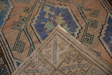 Distressed vintage Melas rug: textured pile with faded terracotta, blue, and visible foundation weave.