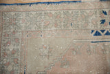 Distressed Melas rug corner, geometric rose and silver border, cobalt blue selvage.