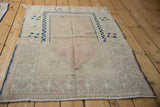 Corner detail of the distressed Melas rug with cobalt blue selvage and worn geometric patterns.