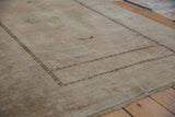 Distressed Oushak rug corner showing stepped motifs, subtle patterns, and textural wear.