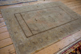 Corner view of the distressed vintage Oushak rug, highlighting intact selvage and short fringe.