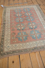 Distressed Oushak rug with blush zig zag border, blue geometric guls, and fringe.