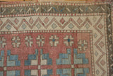 Distressed geometric guls on abrashed pale ruby red ground, with zig-zag border.