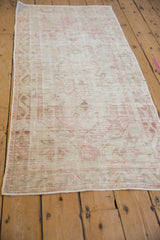 Distressed ivory and pink vintage Oushak rug runner edge with intact side selvage.