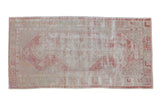 Distressed vintage Oushak runner with a faded hexagonal medallion in pale raspberry red and ivory.