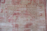 Worn knot heads and exposed foundation on a distressed vintage Oushak rug runner.