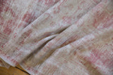 Distressed texture of a vintage Oushak rug with raspberry pile worn to its ivory foundation.