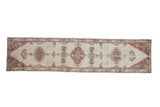 Vintage distressed Sparta rug runner with a column of pale brick red and silver medallions on an open ivory field.