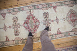 Overhead view of the distressed vintage runner's low-pile texture and medallions.