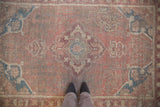 Distressed Anatolian rug with wear across knot heads, dusty mauve rose and sapphire blue.