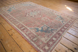 Distressed Anatolian rug corner, showing aged dusty mauve rose field, sapphire blue samovar spandrel.