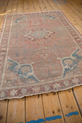 Distressed texture of vintage Anatolian rug with dusty mauve rose and sapphire blue vines.