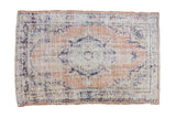 Vintage distressed Oushak rug with a roundel medallion in dusty apricot, ivory, and cobalt blue.