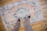 A scale view of the vintage distressed Oushak rug's worn texture and decorative character.