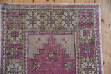 View of the stepped prayer design and serrated palmette border on a distressed Oushak rug.