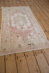 A long view of a vintage Turkish Oushak runner, highlighting its distressed texture and soft colors.