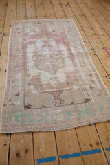 Angled view of a vintage Oushak runner, showing its distressed texture and faded medallion.