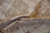 Close-up of a draped vintage Oushak rug showing its distressed texture and wear to the knot heads.