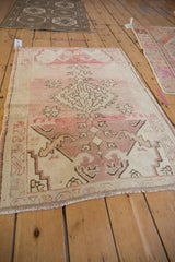 Distressed vintage Oushak rug, featuring an abrashed field and geometric medallion.