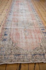 Distressed vintage Sparta runner with blush field, dusty cobalt border, and worn palmette motifs.