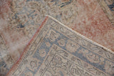 Distressed Sparta rug corner: blush, cobalt blue border, worn pile, and pink selvage.