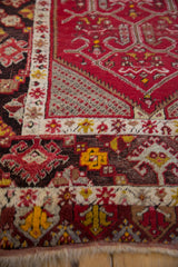 Detailed corner view of a Turkish runner with cherry red trellis medallions and ivory borders.