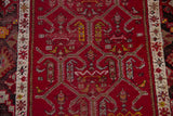 Close-up showing stylized samovar panels and trellis medallions on the cherry red field.