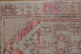 Distressed Oushak rug detail: mostly even wear to pile, with rust-beige geometric pattern.