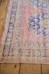Distressed Oushak runner showing dusty pink, cobalt blue, ivory, and exposed foundation.