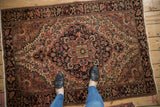Vintage Farahan Sarouk rug corner, with elaborate floral and vine motifs in blush and navy.