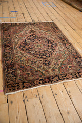Vintage Persian Farahan Sarouk rug corner, detailed floral pattern with deep blush and navy.