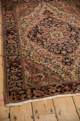Farahan Sarouk rug's intricate navy border and dusty blush floral, dragon motifs.