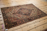 Vintage Farahan Sarouk rug corner, ornate navy border, floral details, soft pile, and fringe with tag.