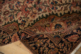 Rolled vintage Farahan Sarouk rug detail showing soft pile, deep dusty blush floral motifs, and fringe.