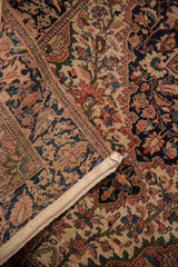 Vintage Farahan Sarouk rug's intricate floral pattern, time-softened reds, navy, beige, and original selvage.