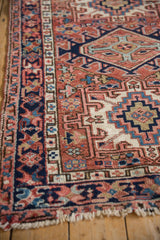 Vintage Karaja rug close-up of geometric vine and crab starburst border in dusty red, navy.