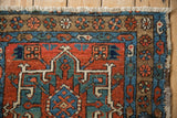 Karaja rug corner: hand-knotted fringe, floral border, brick red and sapphire blue patterns.