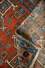 Hand-knotted Karaja rug pile showing exposed woven foundation, brick red and blue.