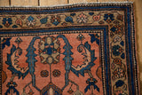 Vintage Mehreban rug corner showcasing dusty blush field, blue border, and finned blossoms.