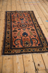 Dusty blush Mehreban rug with unique finned blue blossoms and traditional floral border.