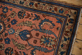 Mehreban rug's finned blossoms, scrolled leaves, and pomegranate motifs with dusty blush and sapphire blue.