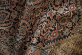 Detailed Herati pattern with dusty terracotta, sapphire blue abrashes, and textured pile.