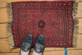 Vintage Afghan rug field, floral top views with inverted coloration in cherry reds.