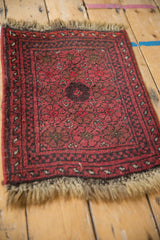 Vintage Afghan rug corner, dusty cherry red floral pattern, intact selvage, and fringe.