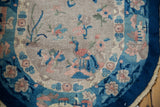 Curved edge of vintage Art Deco Nichols rug, showing peacock and blossoms in cobalt blue, blush, and oxidized silver.
